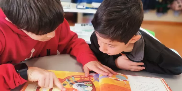 Apadrinament lector: Un alumne de 6è de primària fent de padrí lector d'un alumne de 1r de primària