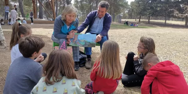 Alumnes de 1r de primària en l'activitat de conta-contes amb padrines i padrines realitzada al pati del Claver.