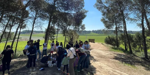 Famílies participant del Taller Natura al bosc del Claver amb els seus fills i filles de fins 3 anys
