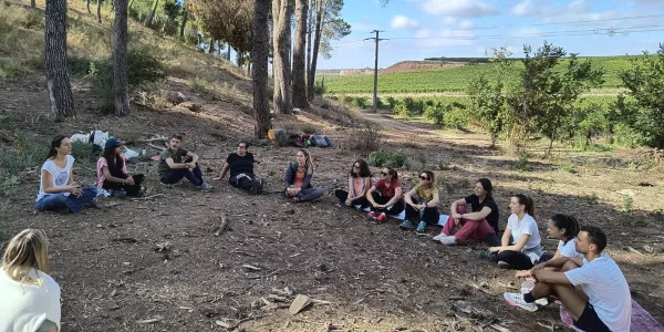 Docents d'infantil i primària al bosc de l'escola en sessions de modelatge d'escola de bosc amb Maria Castella en el marc del projecte Claver Natura