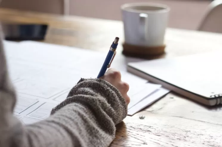 Escribiendo junto una taza de café